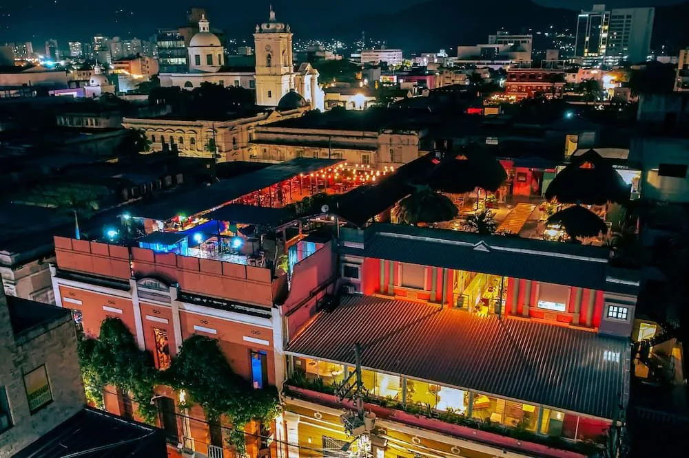 La terraza de la azotea de noche, con el Centro iluminado al fondo