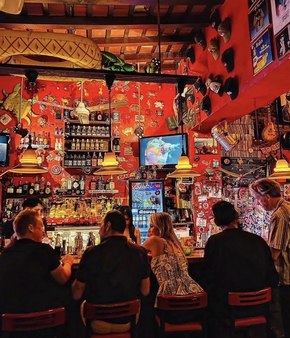 El interior del bar, con la barra y las paredes rojas