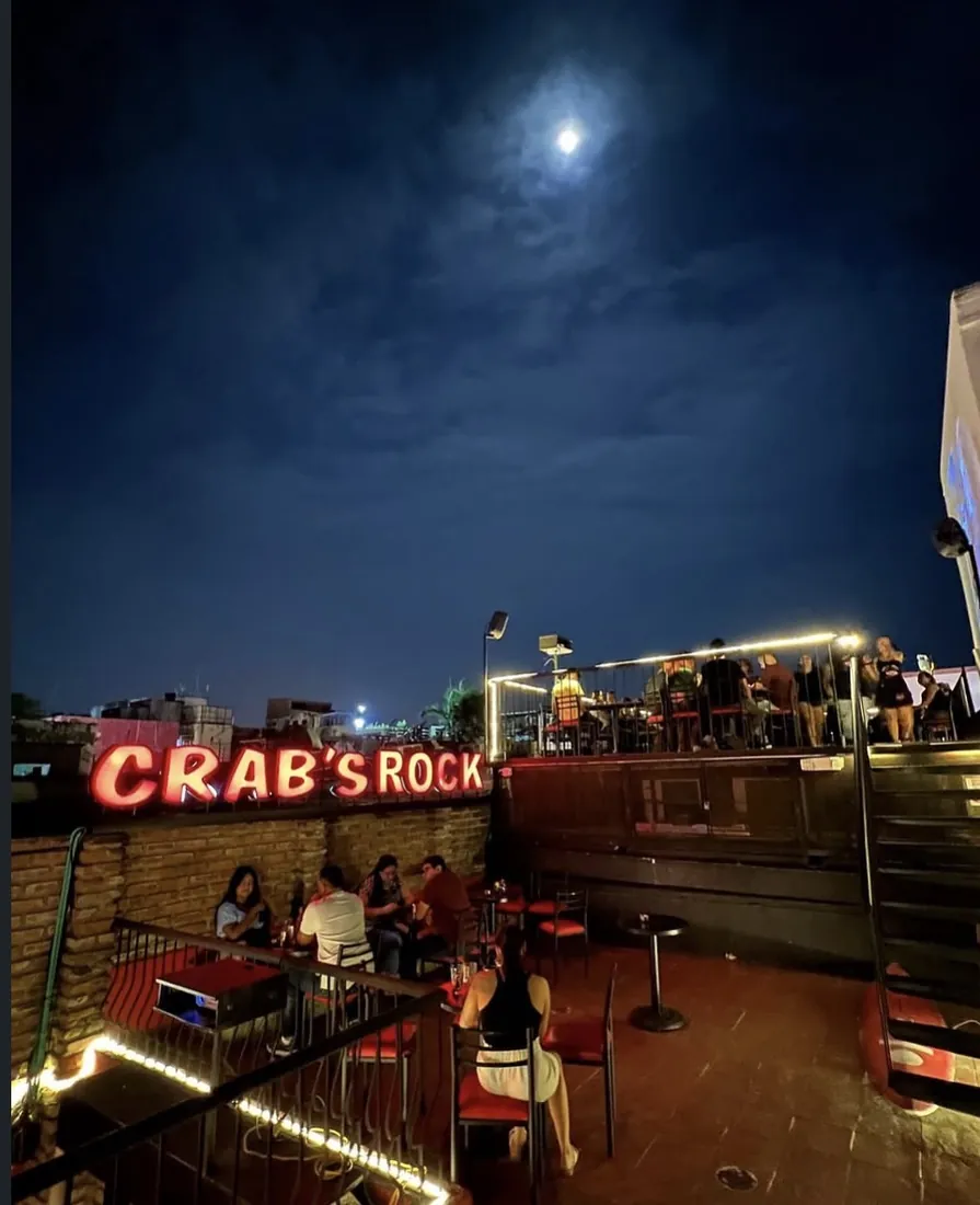 La azotea de noche, con el letrero de Crab's Rock bajo el cielo abierto