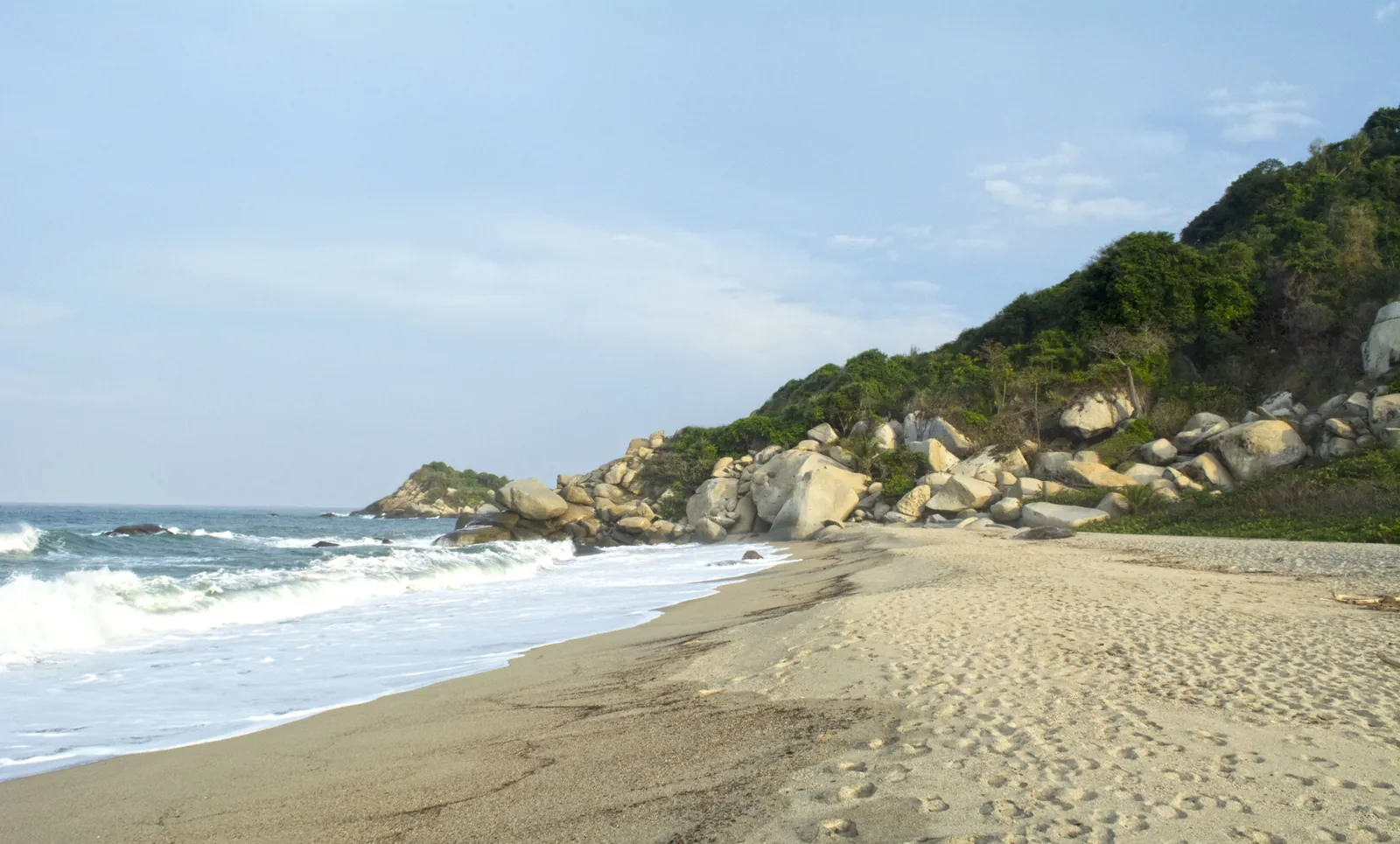 La playa de Arrecifes, con el oleaje rompiendo y la montaña al fondo