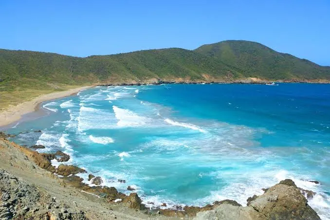 El oleaje de Playa Brava rompiendo, con los cerros alrededor